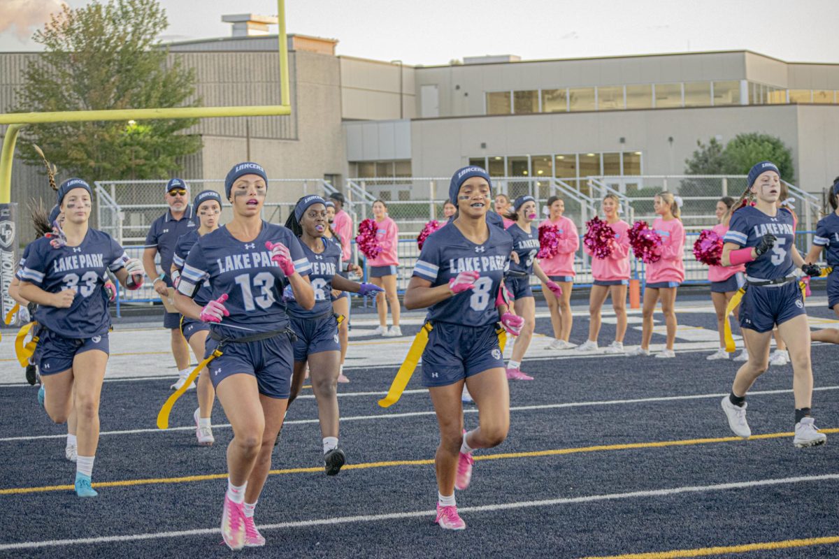The girl's flag football team takes the field before their August 29th contest vs. the Conant Cougars. Left to right: Harper Downs, Head Coach Mr. Pete Kolzow, Dior Hearn, Taliyah Claybon, Gianna Goldsmith, and Teagan White.