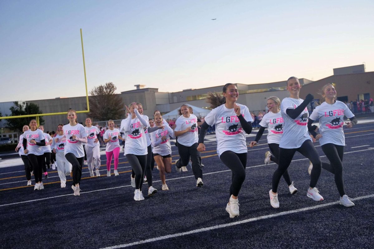 A team of LP students enteres the field for their flag football competition as part of a tournament to raise funds for breast cancer research.